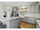 Well-lit kitchen with stainless steel appliances, white backsplash, a farmhouse sink and wood floors at 221 Old Hickory Dr, Raleigh, NC 27603