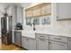 Kitchen area featuring a farmhouse sink, grey cabinets, stainless steel appliances, and great natural light at 221 Old Hickory Dr, Raleigh, NC 27603