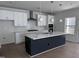 Modern kitchen features a central island, white cabinets, and stainless steel appliances at 3275 Roundly Rd # 10, New Hill, NC 27562