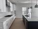 Bright kitchen with white cabinets, quartz countertops, stainless appliances, and a dark island at 3275 Roundly Rd # 10, New Hill, NC 27562