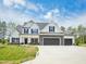 Two-story home featuring a three car garage, stone accents, black shutters and a well-manicured lawn at 38 Hewitt Woods Dr, Clayton, NC 27527
