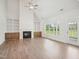Living room with fireplace, white built-in shelves, ceiling fan and a door leading to backyard at 38 Hewitt Woods Dr, Clayton, NC 27527