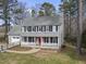 Traditional two-story home with a cozy front porch, red door, gray siding, and mature trees at 4224 Sancroft Dr, Apex, NC 27539
