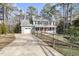 Charming two-story home with a gray exterior, front porch, and a long driveway lined with trees and a wooden fence at 4224 Sancroft Dr, Apex, NC 27539