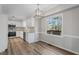 Eat-in kitchen featuring white cabinets, wood floors, and stainless steel appliances at 4224 Sancroft Dr, Apex, NC 27539