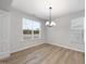 Bright dining area with hardwood floors, elegant chandelier, large window, and classic white trim at 45 Nimble Way # 180, Clayton, NC 27520