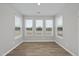 A sun-drenched room featuring three large windows with blinds and gleaming wood floors at 45 Nimble Way # 180, Clayton, NC 27520