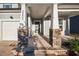 Front porch with stone columns and a dark brown front door at 5205 Doughtymews Ln, Fuquay Varina, NC 27526