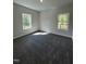 A cozy bedroom with plush gray carpeting, two bright windows, and neutral gray walls at 65 Watermelon Dr, Franklinton, NC 27525