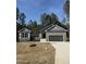 Charming single-story home with gray siding, stone accents, an attached garage, and a well-manicured lawn at 65 Watermelon Dr, Franklinton, NC 27525