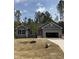 Attractive single-story home with gray siding, stone accents, and an attached two-car garage on a sunny lot at 65 Watermelon Dr, Franklinton, NC 27525