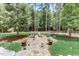 Landscaped backyard with firepit, stone pathway, and lush green grass at 6729 Greywalls Ln, Raleigh, NC 27614