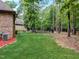 Landscaped backyard with a spacious lawn and wooded backdrop at 6729 Greywalls Ln, Raleigh, NC 27614