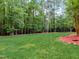 Large backyard with a grassy area and mature trees at 6729 Greywalls Ln, Raleigh, NC 27614