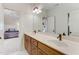 Double vanity bathroom with wood cabinets and view into bedroom at 6729 Greywalls Ln, Raleigh, NC 27614