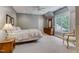 Cozy bedroom with a queen bed and an armchair at 6729 Greywalls Ln, Raleigh, NC 27614