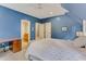 Relaxing bedroom with blue walls, ensuite bathroom access, and a desk area at 6729 Greywalls Ln, Raleigh, NC 27614