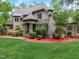 House exterior featuring stone and brick accents, landscaping, and a spacious lawn at 6729 Greywalls Ln, Raleigh, NC 27614