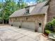 Four-car garage with light gray doors and brick exterior at 6729 Greywalls Ln, Raleigh, NC 27614