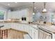 White kitchen with granite countertops, stainless steel appliances, and hardwood floors at 6729 Greywalls Ln, Raleigh, NC 27614