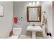 Small powder room with pedestal sink and decorative mirror at 6729 Greywalls Ln, Raleigh, NC 27614