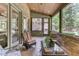 Inviting screened porch featuring brick walls, wicker furniture, and lush greenery views at 6729 Greywalls Ln, Raleigh, NC 27614