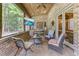 Cozy screened porch with brick flooring, comfortable seating, and a large TV at 6729 Greywalls Ln, Raleigh, NC 27614