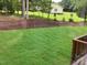 View of a freshly sodded lawn and mulched flower beds, framed by a classic home in the background at 716 Spirit Hill Dr, Hillsborough, NC 27278