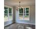 Bright dining area featuring hardwood floors, modern chandelier, and large windows offering scenic views at 716 Spirit Hill Dr, Hillsborough, NC 27278