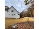 Back exterior view of a bright home featuring an inviting screened porch and a vast, well-maintained lawn at 716 Spirit Hill Dr, Hillsborough, NC 27278