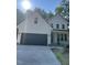 Striking two-story home showcasing a black garage door, white exterior, covered porch, and professional landscaping at 716 Spirit Hill Dr, Hillsborough, NC 27278