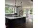 Spacious kitchen with a large center island, modern appliances, stylish light fixtures, and natural light at 716 Spirit Hill Dr, Hillsborough, NC 27278