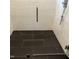 Contemporary shower with sleek black tile flooring, white subway tile walls, and a glass door at 716 Spirit Hill Dr, Hillsborough, NC 27278