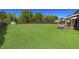 Spacious backyard with a lush green lawn, mature trees, and a charming bench seating area at 7945 Parker Mill Trail, Fuquay Varina, NC 27526