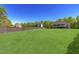 Expansive grassy backyard with a view of the house and trees at 7945 Parker Mill Trail, Fuquay Varina, NC 27526