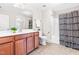 Bathroom with a white vanity, toilet, decorative shower curtain, and a large mirror at 7945 Parker Mill Trail, Fuquay Varina, NC 27526