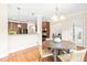 Dining room with hardwood floors, kitchen view, modern lighting fixture and doorway to living area at 7945 Parker Mill Trail, Fuquay Varina, NC 27526