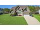 Charming two-story home boasts lush green lawn, attached garage, and attractive landscaping at 7945 Parker Mill Trail, Fuquay Varina, NC 27526