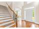 Bright foyer featuring hardwood floors, soaring ceilings, staircase, and arched doorway at 7945 Parker Mill Trail, Fuquay Varina, NC 27526
