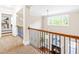 A hallway overlooks a two-story fireplace and provides lots of natural light through many windows at 7945 Parker Mill Trail, Fuquay Varina, NC 27526