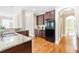 Kitchen with granite countertops, stainless sink, dark cabinets and black refrigerator with hardwood floors at 7945 Parker Mill Trail, Fuquay Varina, NC 27526