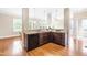 Open kitchen features granite countertops, tiled backsplash, stainless steel appliances, and dark wood cabinets at 7945 Parker Mill Trail, Fuquay Varina, NC 27526