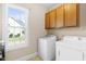 Bright laundry room with modern washer and dryer, and window offering exterior view at 7945 Parker Mill Trail, Fuquay Varina, NC 27526