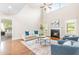 Comfortable living room features a fireplace, large windows, and hardwood floors at 7945 Parker Mill Trail, Fuquay Varina, NC 27526