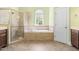 Luxurious main bathroom showcasing a walk-in shower, soaking tub, tile flooring, and ample counter space at 7945 Parker Mill Trail, Fuquay Varina, NC 27526