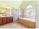 Luxurious main bathroom showcasing a walk-in shower, soaking tub, tile flooring, and ample counter space at 7945 Parker Mill Trail, Fuquay Varina, NC 27526