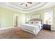 Main bedroom featuring tray ceiling, and carpeted floors, ensuite bath and walk-in closet at 7945 Parker Mill Trail, Fuquay Varina, NC 27526