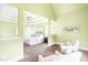 A cozy sitting area and spacious main bedroom feature large windows that provide ample natural light, carpet, and neutral paint at 7945 Parker Mill Trail, Fuquay Varina, NC 27526