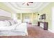 Spacious main bedroom featuring a tray ceiling, neutral paint, and a cozy sitting area with natural light at 7945 Parker Mill Trail, Fuquay Varina, NC 27526
