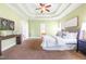 Main bedroom with soft green walls, tray ceiling, and neutral color scheme at 7945 Parker Mill Trail, Fuquay Varina, NC 27526